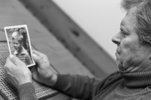Black and White Portrait of Elderly Man Looking at Portrait of Young Boy