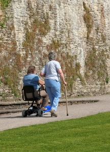 Woman in Wheelchair, Woman with Cane Walking
